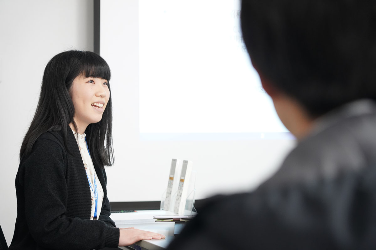 学生に会社概要を説明する女性社員