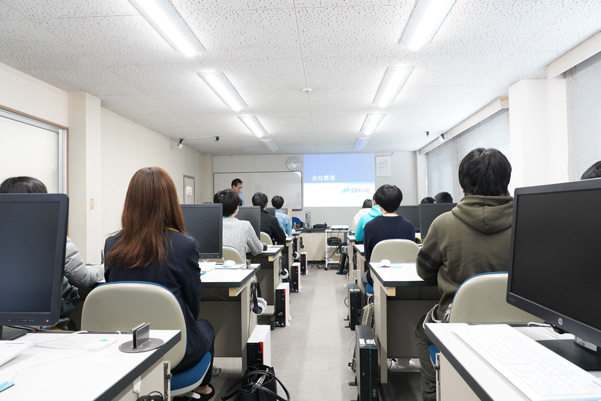 研修室で会社説明を聞く学生達